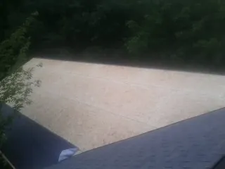 New OSB roof sheathing installed beside an existing shingle roof in Maysville